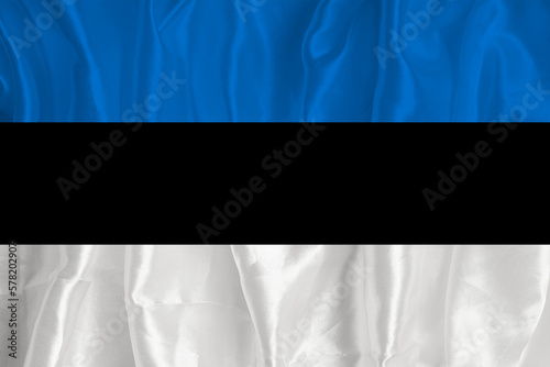 The flag of Estonia on a silk background is a great national symbol. Fabric texture The official state symbol of the country.