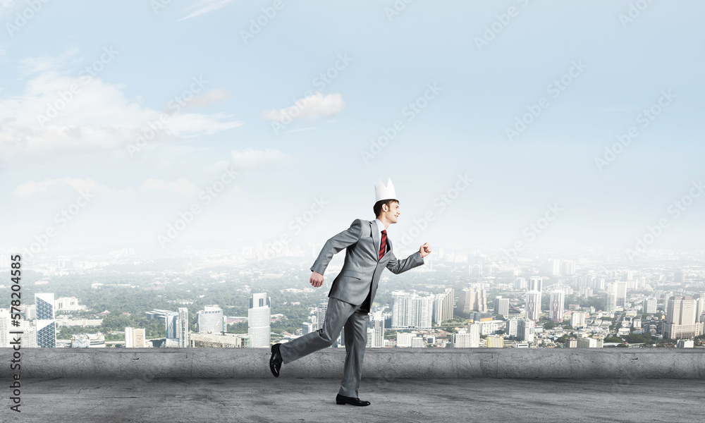 King businessman in elegant suit running on building roof and business center at background King businessman in elegant suit running on building roof and business center at background