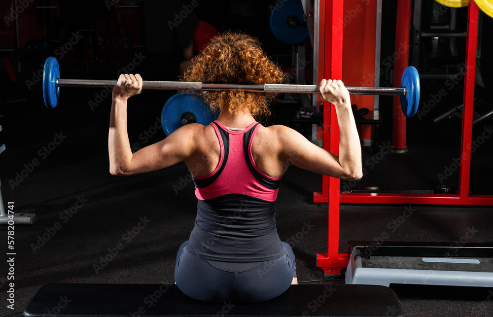 Woman bodybuilder engaged with a barbell in the gym Woman bodybuilder engaged with a barbell in the gym
