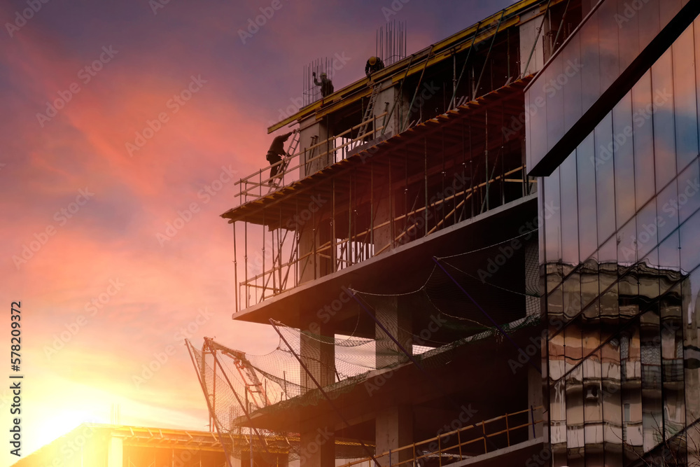 Construction of a new residential building against the backdrop of a beautiful sunset sky.