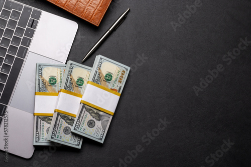 Office desk with cash money on laptop