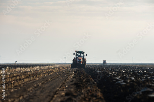The tractor is working in the field, preparing the soil in the fall after harvesting the corn © Vesna
