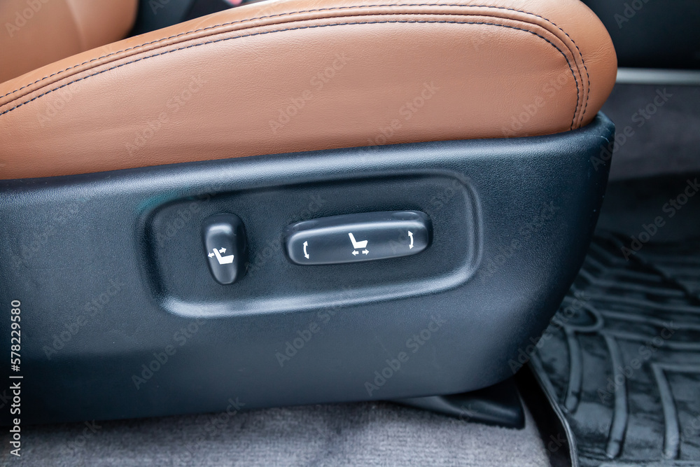 Obraz premium Close-up Interior view with electric seat adjustment, buttons of luxury very expensive new brown car stands after cleaning and detailing in the vehicle repair workshop. Auto service industry