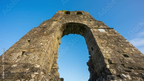 Timelapse of Donaghmore round tower as a historical medieval ruin on sunny day in county Louth in Ireland. photo