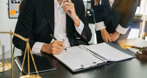 Foto Business and lawyers discussing contract papers with brass scale on desk in office