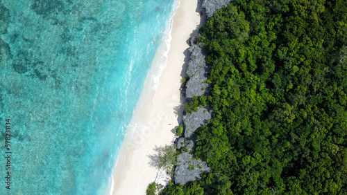 Aerial drone view of uninhabited Jaco Island in Timor-Leste, Southeast Asia, landscape view of long white sandy beach coastline and crystal clear turquoise ocean water