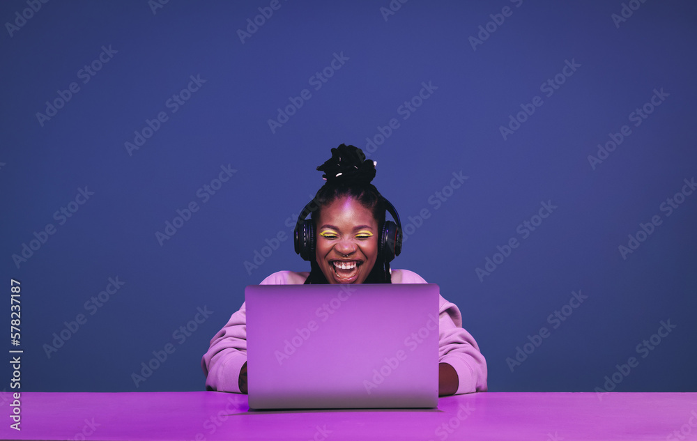 Cheerful female gamer winning an online game on a laptop - obrazy, fototapety, plakaty 