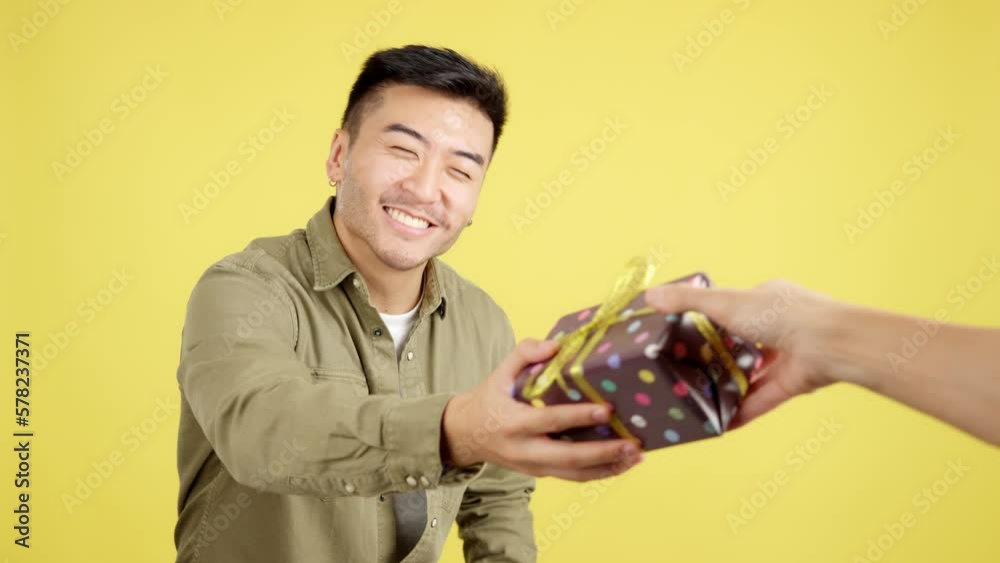Happy chinese man smiling while receiving a gift Happy chinese man smiling while receiving a gift