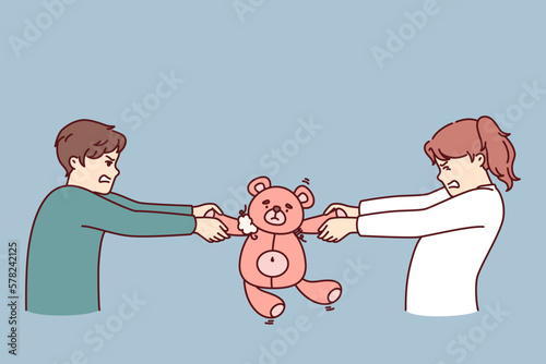 Preteen boy and girl argue over right to play with teddy bear in attempt to take toy away from rival. Kindergarten children are unwilling to share toys after disagreement or conflict