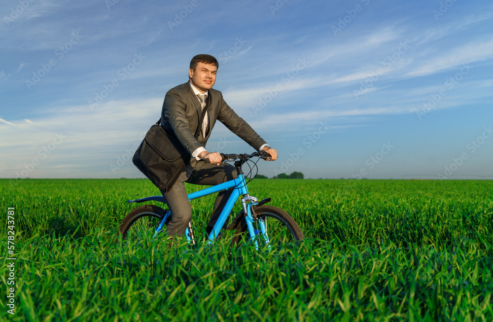a businessman rides a bicycle on a green grassy field, dressed in a business suit, beautiful nature in spring, freelance business concept