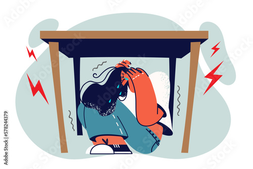 Woman sobs and hides under table in horror during panic attack due to regular stress