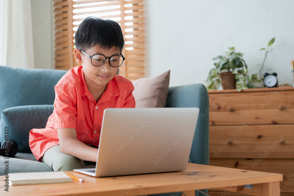 Asian little boy using laptop computer, typing, at home Asian little boy using laptop computer, typing, at home