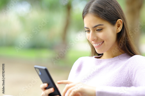 Happy woman checking cell phone