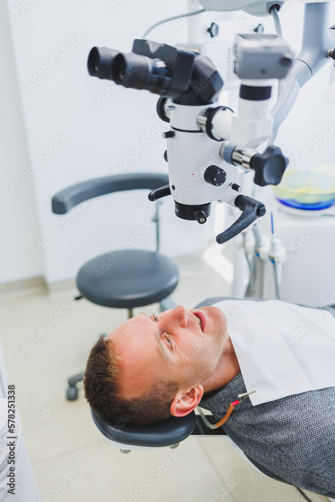 A modern dental clinic with a microscope for treating patients. A dentist uses a microscope to examine a patient's teeth. Medical equipment, dental clinic. A modern dental clinic with a microscope for treating patients. A dentist uses a microscope to examine a patient's teeth. Medical equipment, dental clinic.