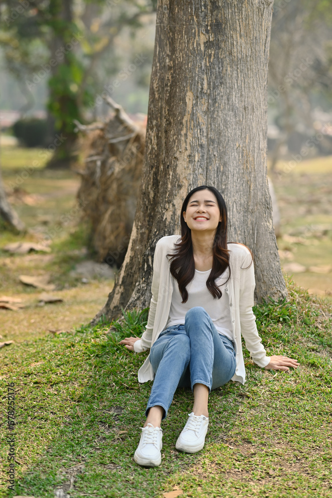 Naklejka premium Portrait of millennial woman relaxing, breathing fresh air and enjoying a day in the park on summer