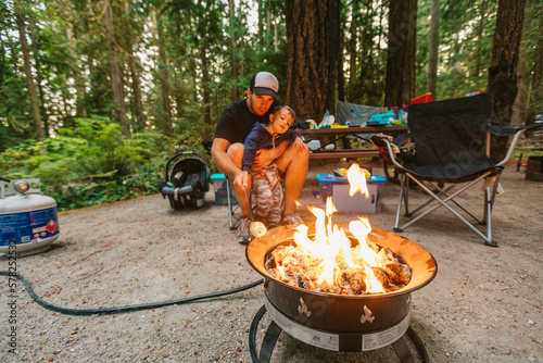 Dad and son roasting marshmallows over propane fire at campsite photo