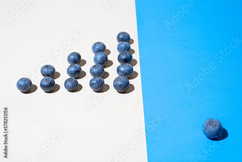 Blueberries lined up on blue paper photo