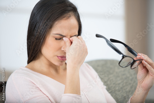 Принти на полотні woman holding glasses to rub the bridge of her nose