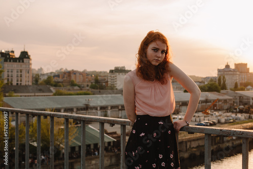 Portrait of young cute woman standing on bridge in city photo