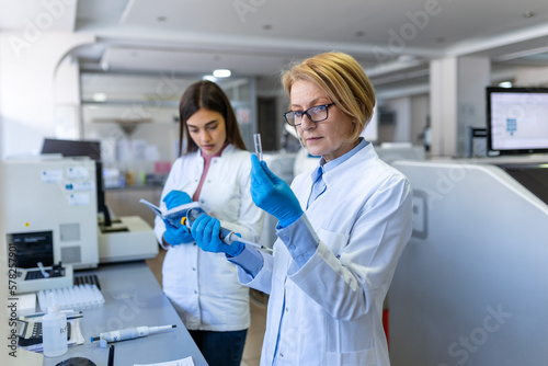 Modern Medical Research Laboratory  Female Scientist Working with Micro Pipette  Using Digital Tablet for Test Sample Analysis. Advanced Scientific Lab for Medicine  Biotechnology Development.
