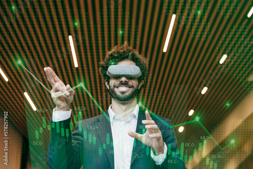 Happy businessman wearing virtual reality simulator gesturing in office photo
