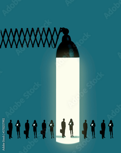 Line of people standing under beam of oversized desk lamp