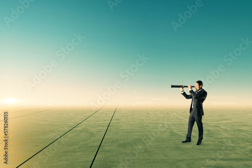 Businessman with telescope looking into the distance on abstract bright sky and ground background with mock up place.