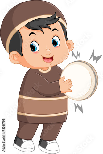 an excited Muslim boy is beating a tambourine