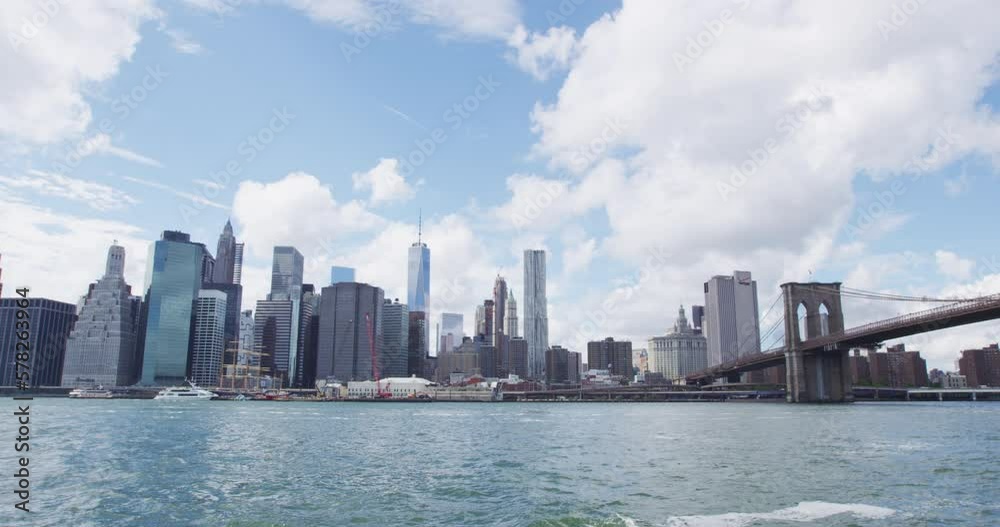 New York City Skyline showing Midtown and Lower Manhattan and Brooklyn Bridge. Iconic New York and famous tourist destination landmarks at the waterfront in brooklyn. SLOW MOTION New York City Skyline showing Midtown and Lower Manhattan and Brooklyn Bridge. Iconic New York and famous tourist destination landmarks at the waterfront in brooklyn. SLOW MOTION
