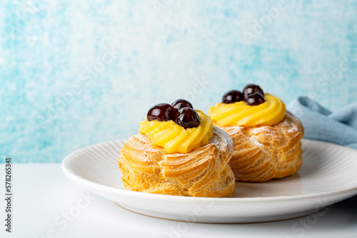 Photographie Italian dessert Zeppole di San Giuseppe, zeppola - baked puffs made from choux pastry,  with custard cream and cherry