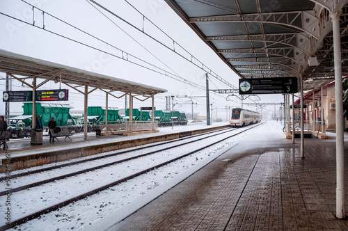 Snowy Villena Train Station. Arrival of a train with snowy tracks.