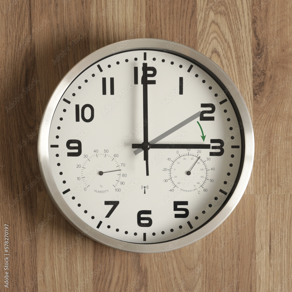 A watch, the gray hand points to two o'clock, the black one to three o'clock. The green arrow indicates the direction of movement of the hands. Time change symbol. Daylight saving time. A watch, the gray hand points to two o'clock, the black one to three o'clock. The green arrow indicates the direction of movement of the hands. Time change symbol. Daylight saving time.
