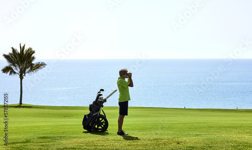 Golfer on a golf course, ready to tee off. Golfer with golf club hitting the ball for the perfect shot.