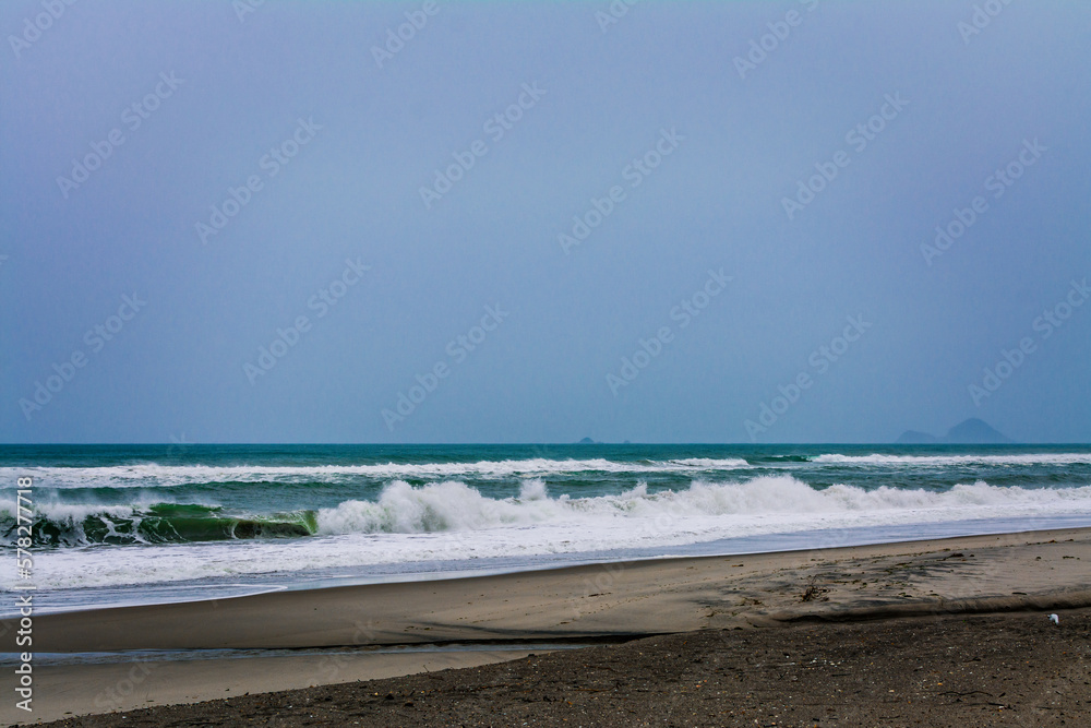 Angry ocean waves breaking on a empty sand beach. Kohe o Awa Beach, Pacific Coast, North Island, New Zealand
