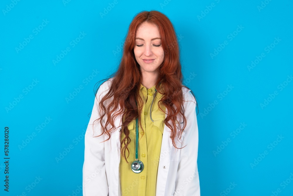 young doctor woman wearing medical uniform over blue background nice-looking sweet charming cute attractive lovely winsome sweet peaceful closed eyes young doctor woman wearing medical uniform over blue background nice-looking sweet charming cute attractive lovely winsome sweet peaceful closed eyes