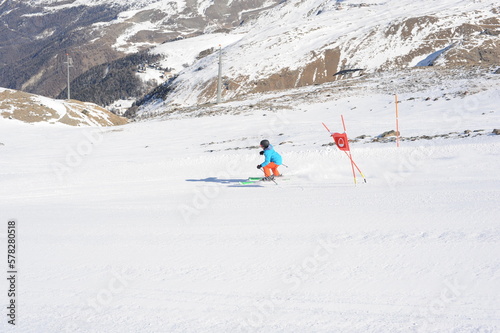 Skier skiing dowhill race on the piste in the mountains. Alps in winter, Europe.