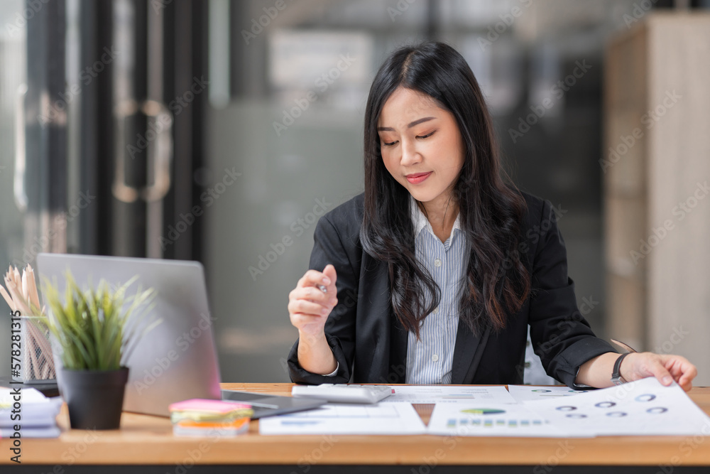 Young business Asian woman using a calculator to Tax deduction planning concept. Businessman calculating business balance prepare loan documents, tax reduction invoices. Young business Asian woman using a calculator to Tax deduction planning concept. Businessman calculating business balance prepare loan documents, tax reduction invoices.
