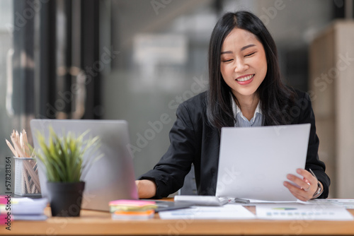 Young business Asian woman using a calculator to Tax deduction planning concept. Businessman calculating business balance prepare loan documents, tax reduction invoices. © David
