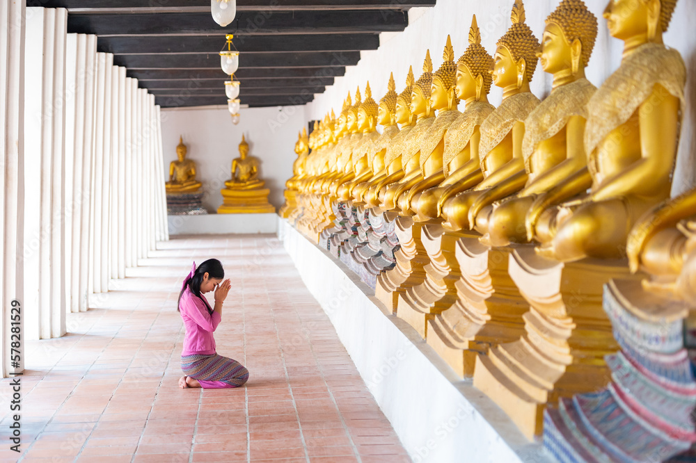 Fototapeta premium Asian woman to pay respect to Buddha statue in thailand.