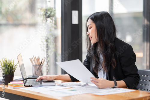Business Asian woman working at office with documents on her desk, doing planning analyzing the financial report, business plan investment, finance analysis concept