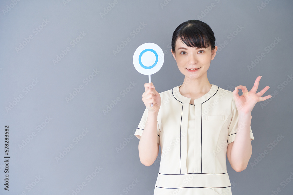 マルバツの棒を持つエステ・美容クリニックの女性