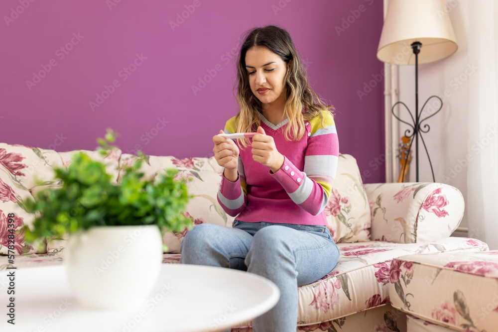 Beautiful cute girl holding pregnancy test and happy with result. Positive pregnancy test, expecting a baby, future mom Beautiful cute girl holding pregnancy test and happy with result. Positive pregnancy test, expecting a baby, future mom