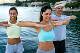 Group of cheerful fit fitness friends team exercising together outdoor. Sport people concept
