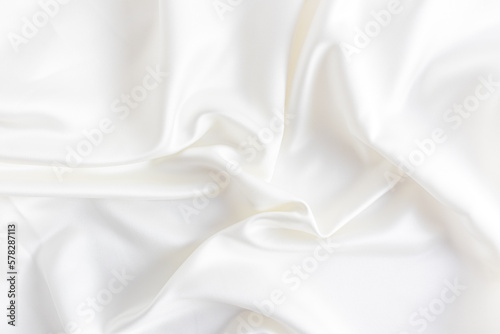 delicate wedding background made of satin fabric with soft waves. the color of champagne, cream. layout.