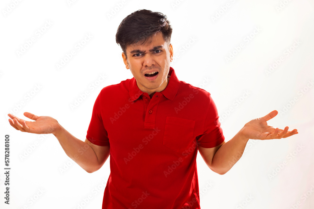 Portrait of young man shrugging against white background Portrait of young man shrugging against white background