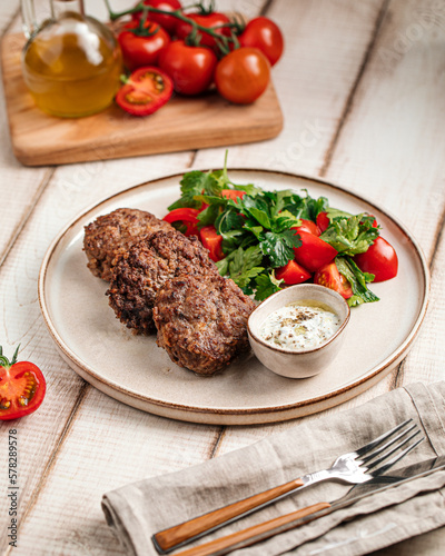 Portion of russian beef cutlets with sauce and salad