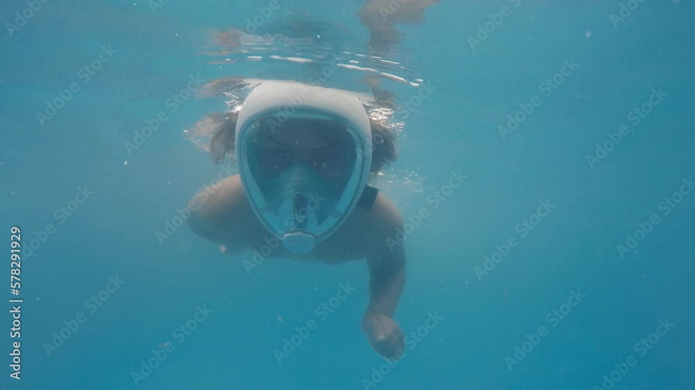 Boy swimming underwater with snorkel mask, 2k slow motion