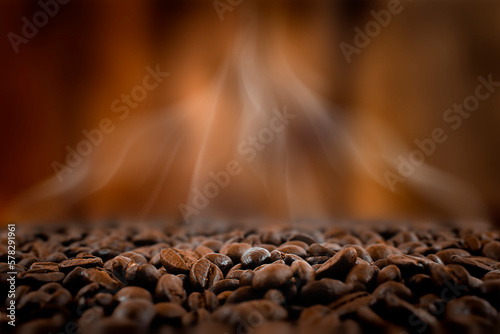 Freshly roasted coffee beans on dark brown defocused background.