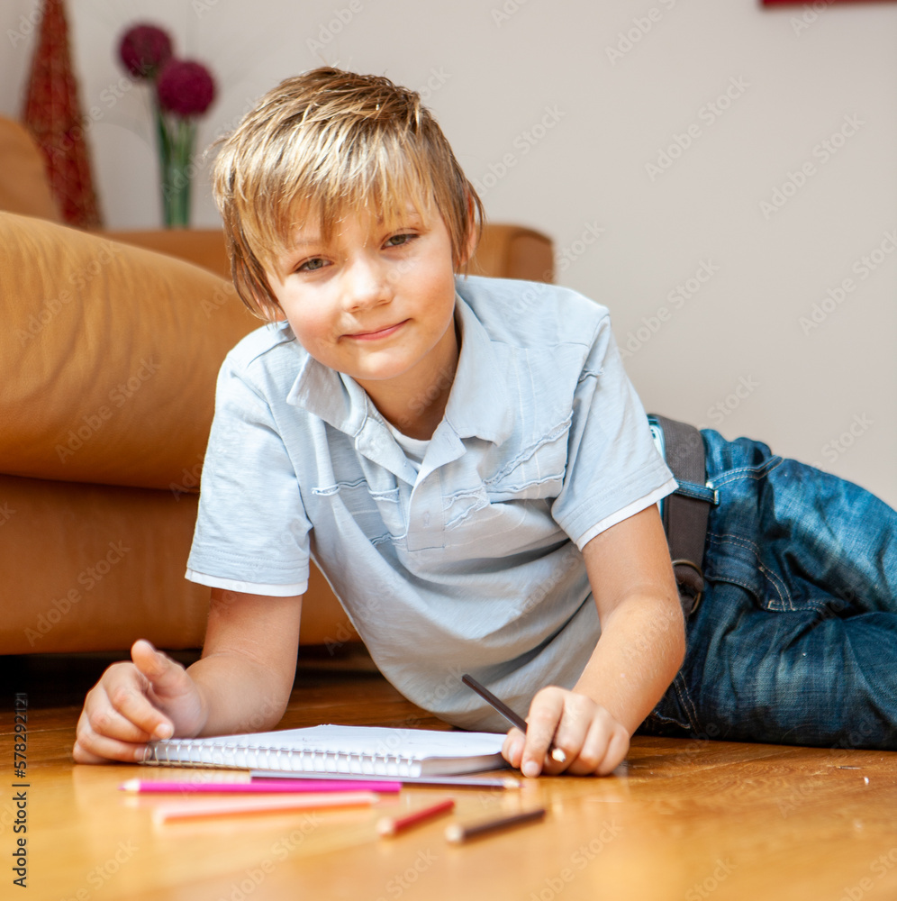 Family Life, Young Artist. A bright smile from young boy exploring his creative and artistic talents at home. From a series of related images.