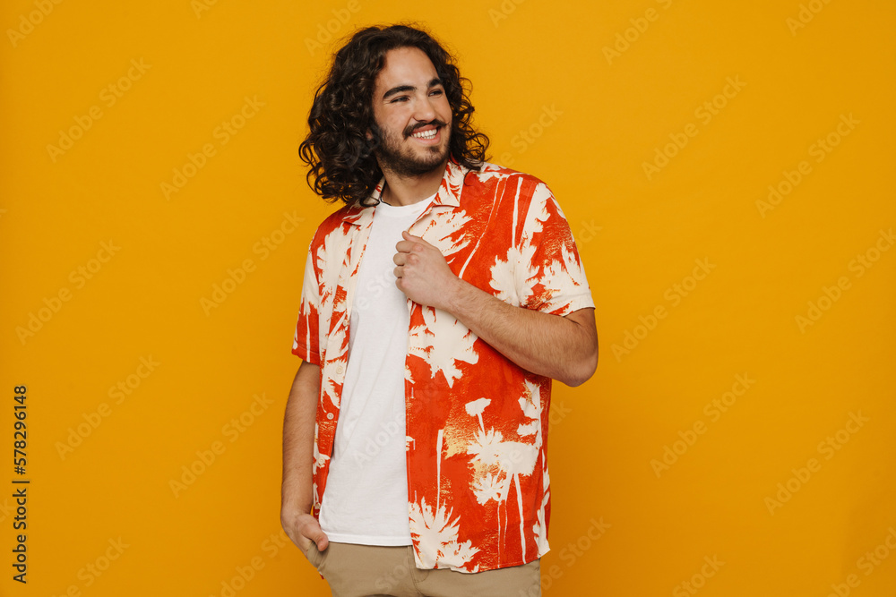Positive hispanic guy posing isolated over yellow wall Positive hispanic guy posing isolated over yellow wall